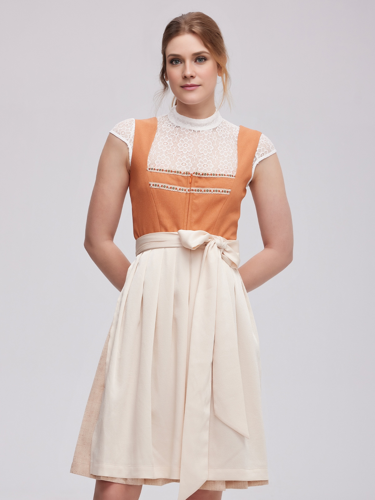 Ein dunkelblaues Dirndl mit traditioneller Schürze und modernen Accessoires